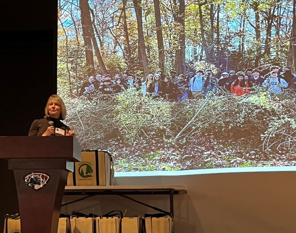 speaker with slide of students outdoors